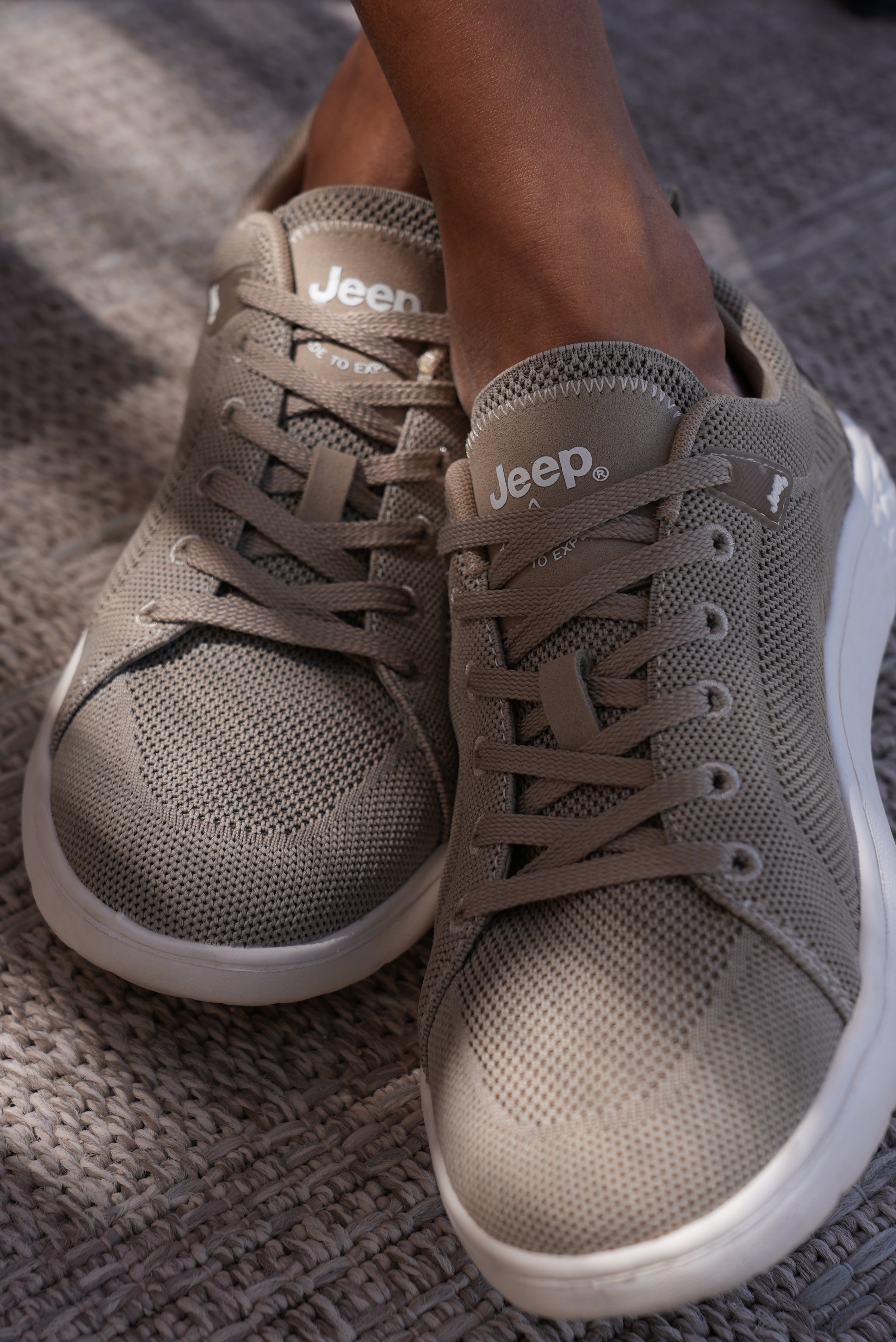 Beige Jeep shoes worn by a Man on a textured surface