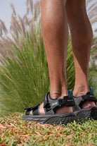 Man wearing black Jeep hiking sandals with a natural background